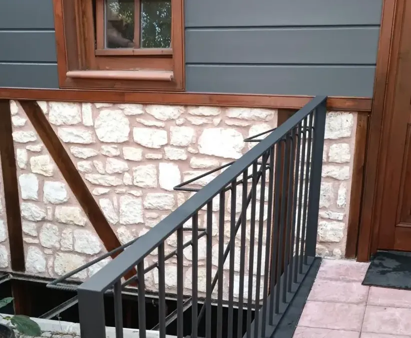 Restore edilmiş tarihi evde taş duvar, ahşap kiriş ve korkuluk detayı